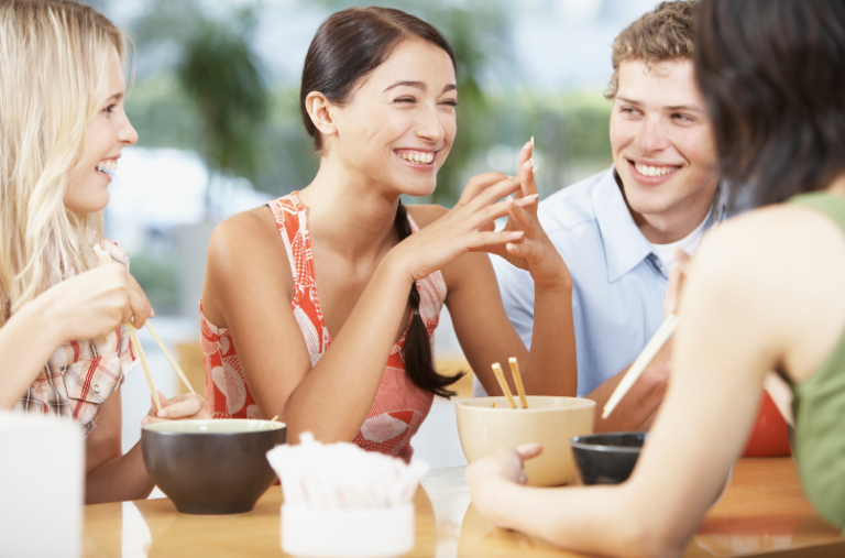 Friends talking and eating a meal together